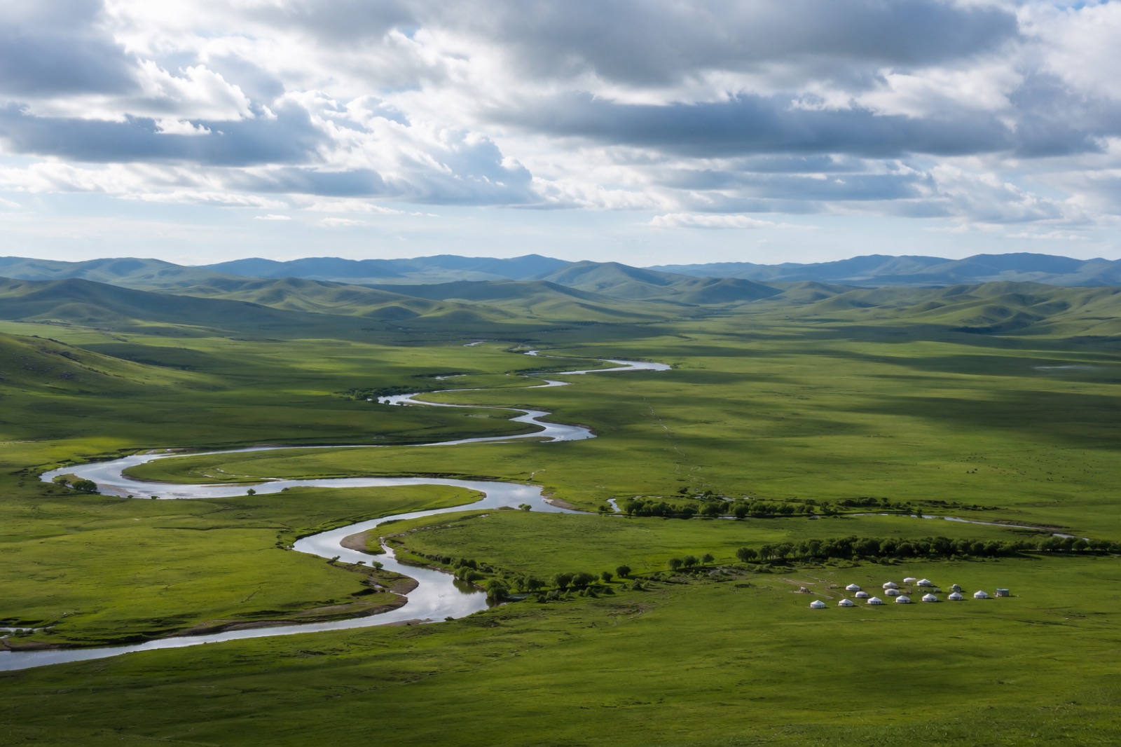 Open grassland and a winding river beneath a wide sky